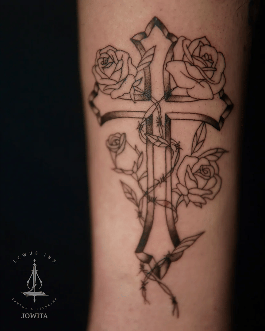 Delikatne tatuaże: krzyż i róże na przedramieniu