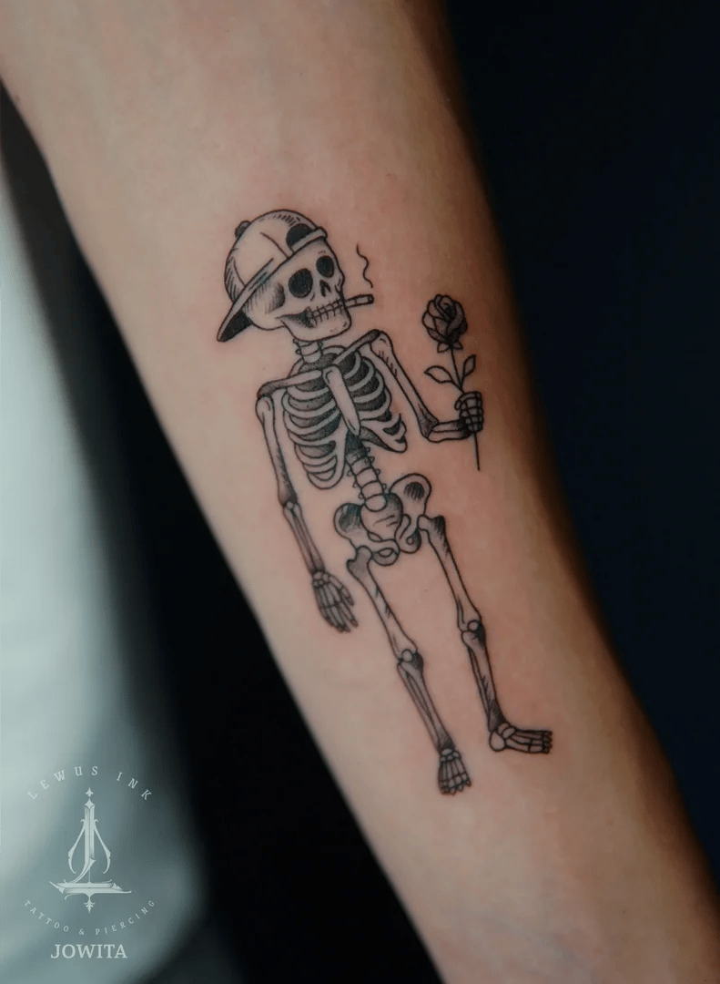 Minimalistyczny tatuaż: szkielecik z różą na przedramieniu